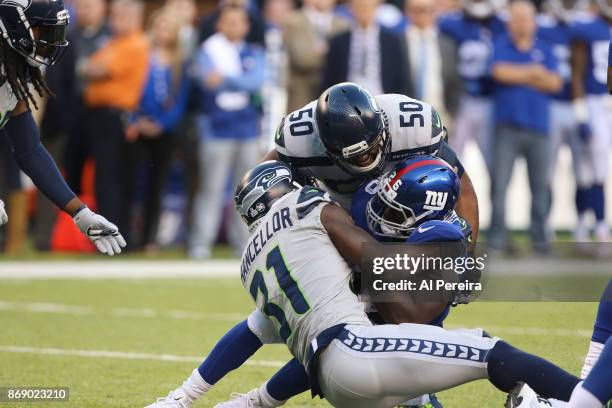 Linebacker K.J. Wright and Safety Kam Chancellor of the Seattle Seahawks make a stop against the New York Giants during their game at MetLife Stadium...