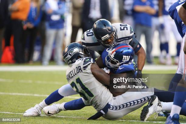 Linebacker K.J. Wright and Safety Kam Chancellor of the Seattle Seahawks make a stop against the New York Giants during their game at MetLife Stadium...