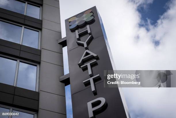 An airplane is seen past signage displayed outside the Hyatt Place hotel in Chicago, Illinois, U.S., on Monday, Oct. 30, 2017. Hyatt Hotels Corp. Is...