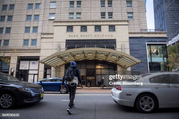 Pedestrian crosses a street in front of the Park Hyatt hotel in downtown Chicago, Illinois, U.S., on Monday, Oct. 30, 2017. Hyatt Hotels Corp. Is...