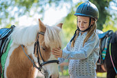 Young girl cuddling her pony horse