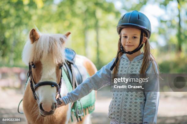 alegre joven con su caballo pony - montar a caballo por placer fotografías e imágenes de stock