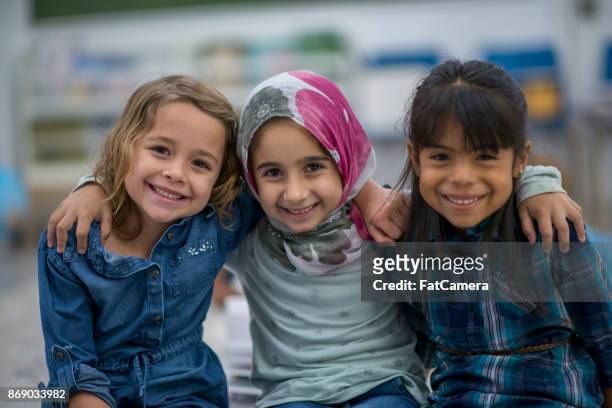 la bambina musulmana e i suoi amici si godono una giornata a scuola insieme. - affettuoso foto e immagini stock