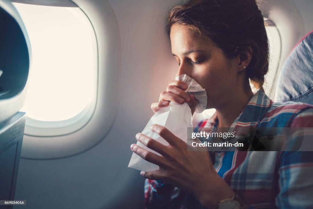 Kranke Frau mit Übelkeit im Flugzeug