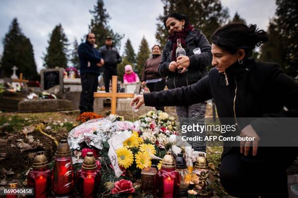 Jana Pokutova pours a liquer spirit on a grave of her deceased relative as a traditional custom of Roma people in Eastern Slovakia, in Levoca on...
