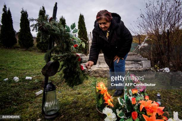 Maria Pokutova pours a liquer spirit on a grave of her deceased relative as a traditional custom of Roma people in Eastern Slovakia, in Levoca on...