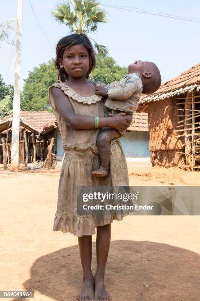 Satia, India Portrait of a young girl holding a crying baby in her arms, in a rural area about 300 Kilometer from Kolkata.