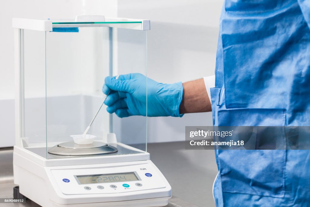 Scientist using an analytical balance