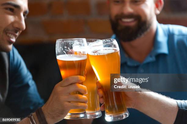 friends drinking beer in the pub - lager stock pictures, royalty-free photos & images