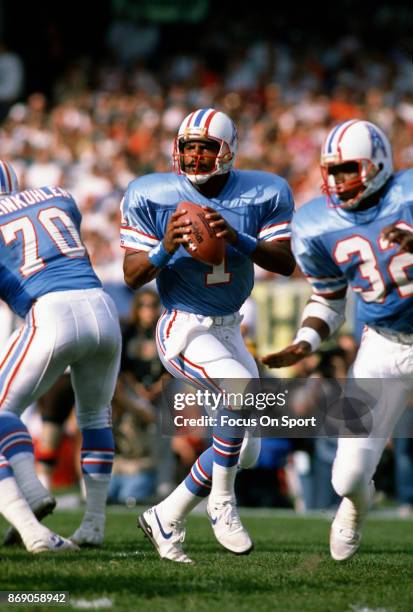 Quarterback Warren Moon of the Houston Oilers looks to pass against the Cleveland Browns during an NFL football game October 29, 1989 at Cleveland...