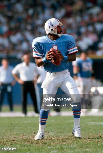 Quarterback Warren Moon of the Houston Oilers drops back to pass against the Cleveland Browns during an NFL football game October 29, 1989 at...