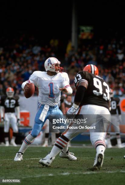 Quarterback Warren Moon of the Houston Oilers drops back to pass against the Cleveland Browns during an NFL football game November 21, 1993 at...