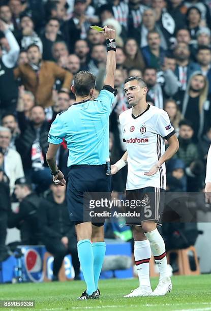 Referee Paolo Tagliavento shows a yellow card to Pepe of Besiktas during UEFA Champions League Group G match between Besiktas and Monaco at the...