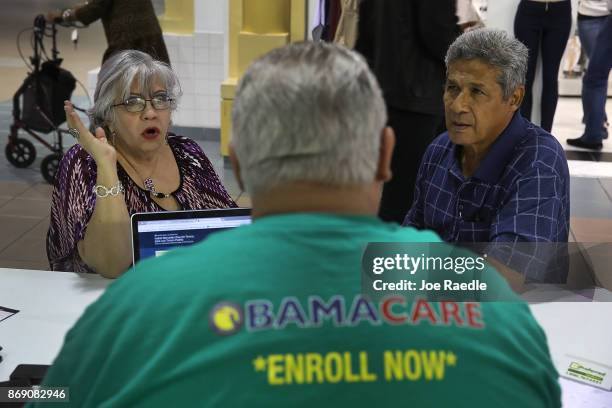 Isabel Diaz Tinoco and Jose Luis Tinoco speak with Otto Hernandez, an insurance agent from Sunshine Life and Health Advisors, as they shop for...