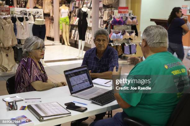 Isabel Diaz Tinoco and Jose Luis Tinoco speak with Otto Hernandez, an insurance agent from Sunshine Life and Health Advisors, as they shop for...