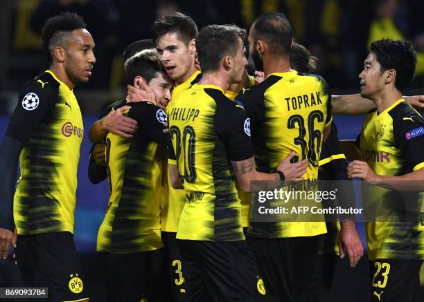Dortmund's Portugese defender Raphael Guerreiro celebrates with teammates after scoring during the UEFA Champions League Group H football match BVB...