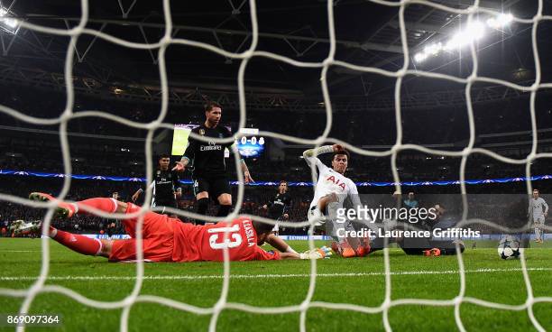 Dele Alli of Tottenham Hotspur beats Francisco Casilla of Real Madrid as he scores their first goal during the UEFA Champions League group H match...