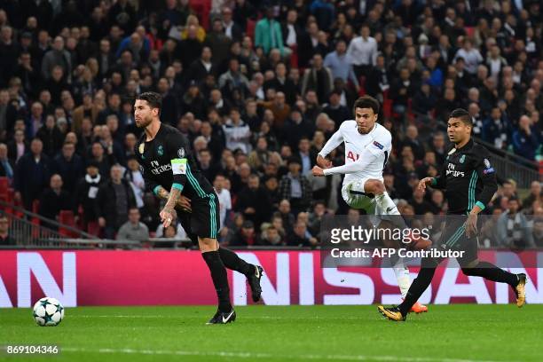 Tottenham Hotspur's English midfielder Dele Alli has this shot deflected off Real Madrid's Spanish defender Sergio Ramos for their second goal during...