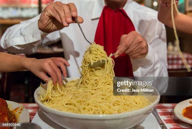 People eating large bowl of spaghetti