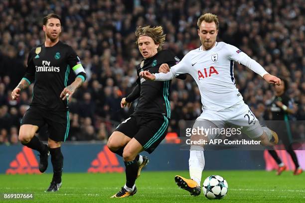 Tottenham Hotspur's Danish midfielder Christian Eriksen shoots past Real Madrid's Croatian midfielder Luka Modric to score their third goal during...
