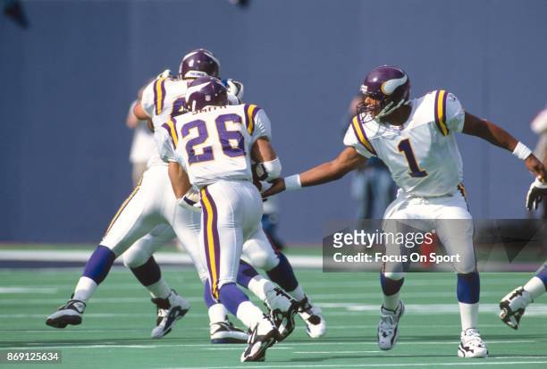Robert Smith of the Minnesota Vikings takes the handoff from quarterback Warren Moon against the New York Giants during an NFL football game...