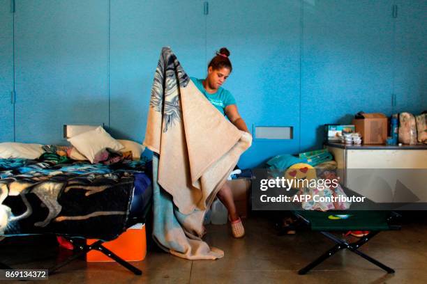 Lusibett Torres makes her bed in a classroom turned bedroom in Barranquitas, Puerto Rico October 31, 2017. Twenty people from Barranquitas have been...