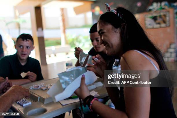 Sharielys Morales eats a military Meal Ready to Eat food in a package in Barranquitas, Puerto Rico October 31, 2017. Twenty people from Barranquitas...