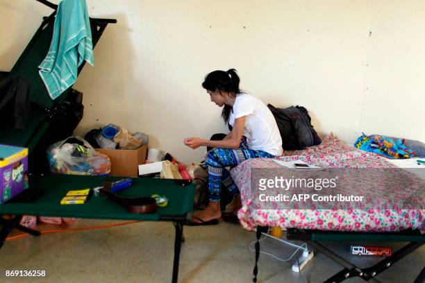 Elsa Diaz looks through her belongings in a classroom turned bedroom in Barranquitas, Puerto Rico October 31, 2017. Twenty people from Barranquitas...