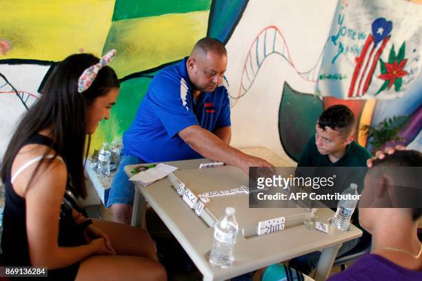 People play dominoes at the school lobby in Barranquitas, Puerto Rico October 31, 2017. Twenty people from Barranquitas have been living for the past...