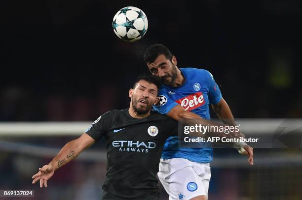 Manchester City's Argentinian striker Sergio Aguero and Napoli's defender from Spain Raul Albiol jump for the ball during the UEFA Champions League...