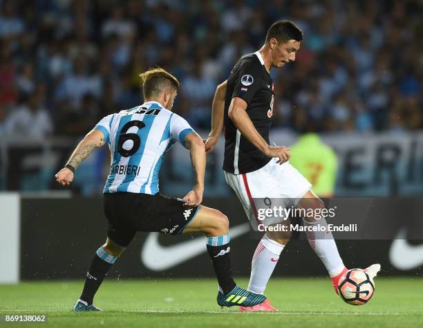 Oscar Cardozo of Libertad and Miguel Barbieri of Racing Club compete for the ball during a second leg match between Racing Club and Libertad as part...