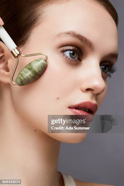 skin care with jade roller - jadesteine stock-fotos und bilder
