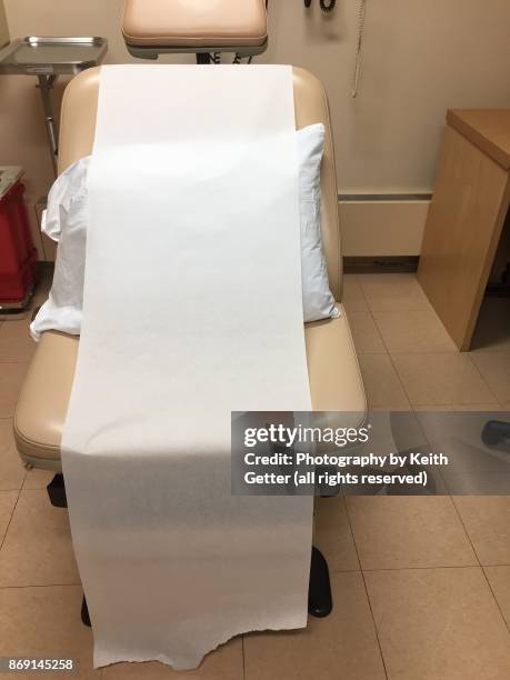 an examination chair with a paper cover in a hospital room - take care new york screening stockfoto's en -beelden