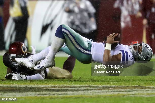 Linebacker Zach Brown of the Washington Redskins tackles quarterback Dak Prescott of the Dallas Cowboys at FedEx Field on October 29, 2017 in...