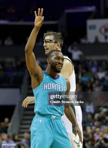 Mirza Teletovic of the Milwaukee Bucks watches as Kemba Walker of the Charlotte Hornets reacts after a shot during their game at Spectrum Center on...