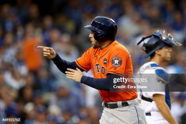 George Springer of the Houston Astros celebrates after scoring off of a single hit by Alex Bregman of the Houston Astros in the first inning and...