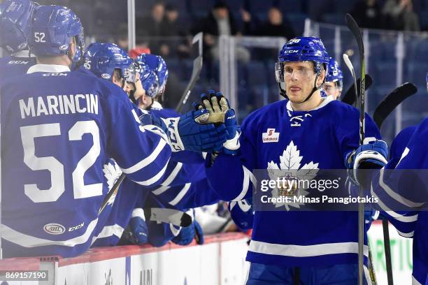 Colin Greening of the Toronto Marlies celebrates his first period goal with teammates on the bench against the Laval Rocket during the AHL game at...