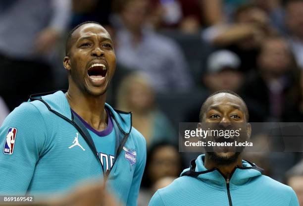 Teammates Dwight Howard and Kemba Walker of the Charlotte Hornets react on the bench during their game against the Milwaukee Bucks at Spectrum Center...