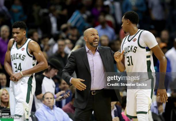 Head coach Jason Kidd talks to his player John Henson of the Milwaukee Bucks against the Charlotte Hornets during their game at Spectrum Center on...