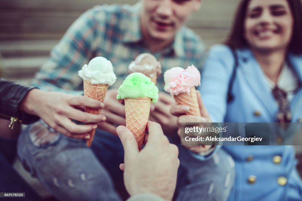 Lächelnde Freunden Eis essen und Zapfen in den Händen halten