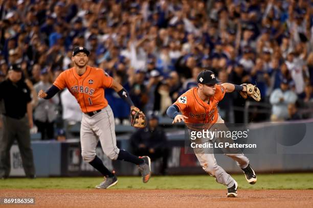 Alex Bregman of the Houston Astros is unable to make the play on a Justin Turner of the Los Angeles Dodgers single in the fifth inning during Game 7...