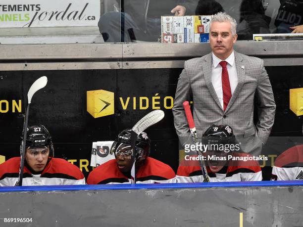 Head coach of the Drummondville Voltigeurs Dominique Ducharme looks on from behind the bench against the Blainville-Boisbriand Armada during the...