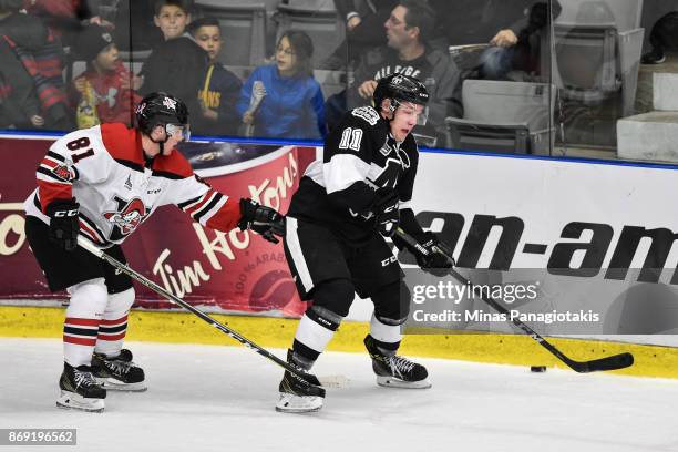 Anthony Poulin of the Blainville-Boisbriand Armada skates the puck against Xavier Simoneau of the Drummondville Voltigeurs during the QMJHL game at...
