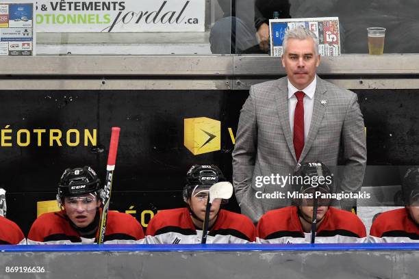 Head coach of the Drummondville Voltigeurs Dominique Ducharme looks on from behind the bench against the Blainville-Boisbriand Armada during the...