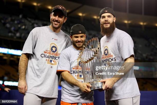 Justin Verlander, Jose Altuve, and Dallas Keuchel of the Houston Astros hold the Commissioner's Trophy after defeating the Los Angeles Dodgers 5-1 in...