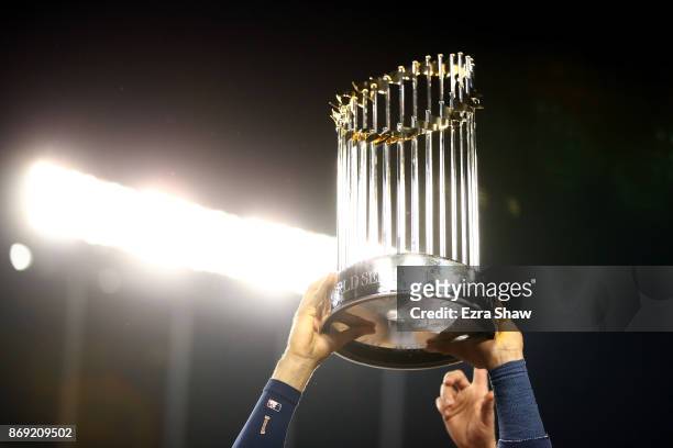 Carlos Correa of the Houston Astros holds the Commissioner's Trophy after defeating the Los Angeles Dodgers 5-1 in game seven to win the 2017 World...