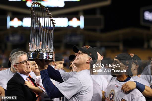 Manager A.J. Hinch of the Houston Astros lifts the Commissioner's Trophy after the Astros defeated the Los Angeles Dodgers in Game 7 of the 2017...