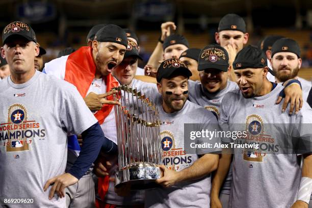 Carlos Correa, Jose Altuve of the Houston Astros pose for a photo with the Commissioner's Trophy after the Astros defeated the Los Angeles Dodgers in...