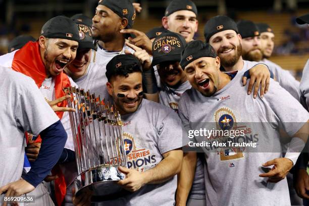 Carlos Correa, Jose Altuve of the Houston Astros pose for a photo with the Commissioner's Trophy after the Astros defeated the Los Angeles Dodgers in...