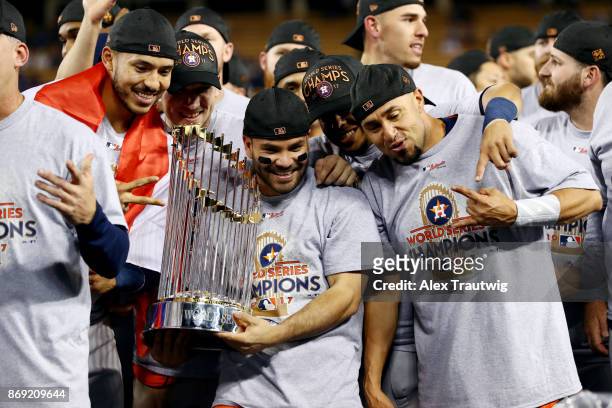 Carlos Correa, Jose Altuve of the Houston Astros pose for a photo with the Commissioner's Trophy after the Astros defeated the Los Angeles Dodgers in...